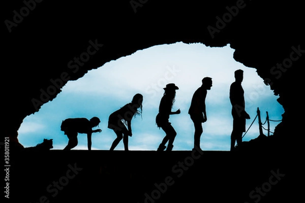 Obraz silhouette of a group of friends with dog in a cave in ibiza. human evolution and fun
