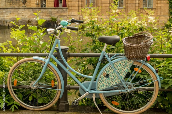 Obraz old blue bicycle with basket at the roadside