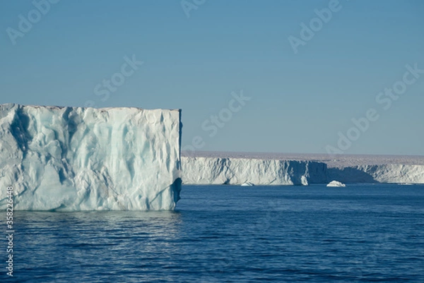 Obraz Tabular iceberg at a place called "Nordaustlandet" on Svalbard. Blue sky and blue water