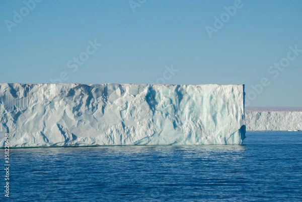 Fototapeta Tabular iceberg at a place called "Nordaustlandet" on Svalbard. Blue sky and blue water