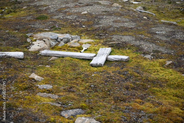 Fototapeta Wooden cross lying on the ground at an old and abandoned grave on Spitsbergen