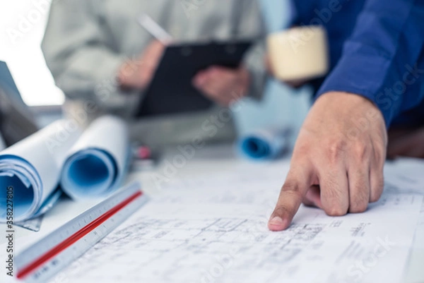 Fototapeta Architect working on blueprint. Architects workplace - architectural project, blueprints, ruler, calculator, laptop and divider compass. Construction concept. Blue print is fake only for stock photo.