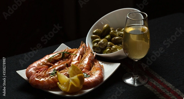 Fototapeta Aperitivo con gambas y aceitunas verdes con copa de vino fino 