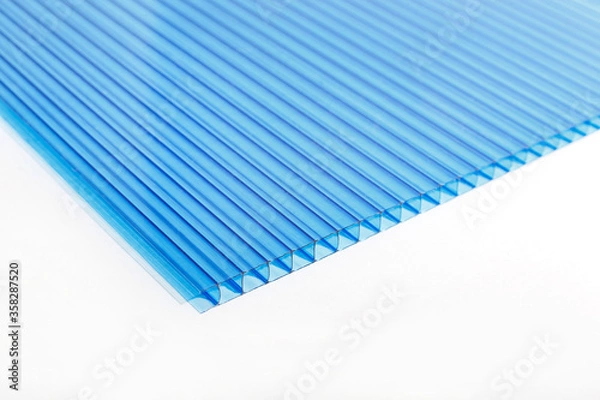 Fototapeta Polycarbonate plastic sheets panels images. PC hollow sheet for translucent roofing close up. Single light blue color on white background