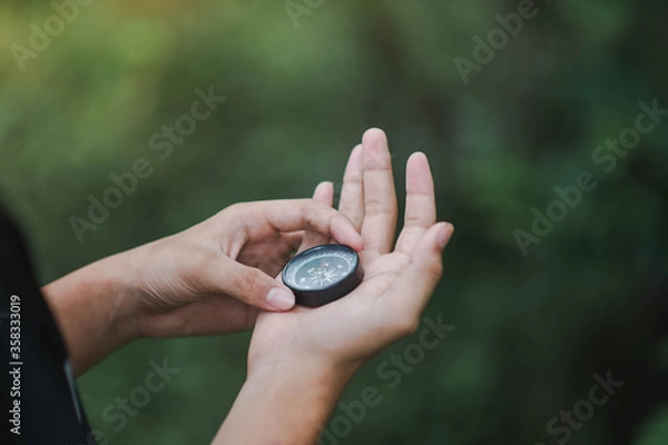 Obraz a man holding a compass in the forest