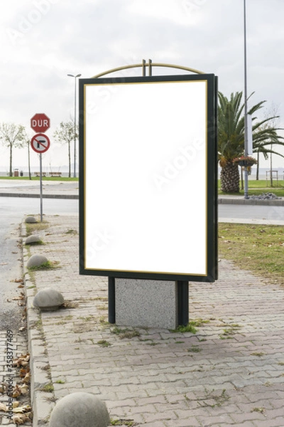 Fototapeta Blank white, vertical mockup of bus stop billboard in empty Caddebostan street