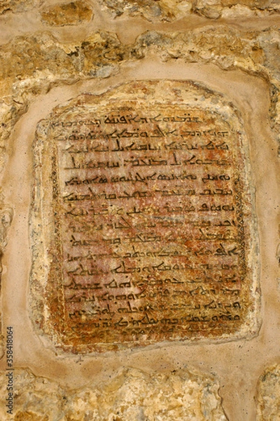 Fototapeta Stone plaque with Aramaic script embedded in wall at Deyrulumur Monastery in  Midyat, Eastern Anatolia, Turkey