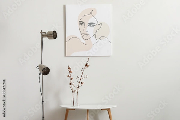 Fototapeta Stylish lamp and table with cotton flowers near light wall
