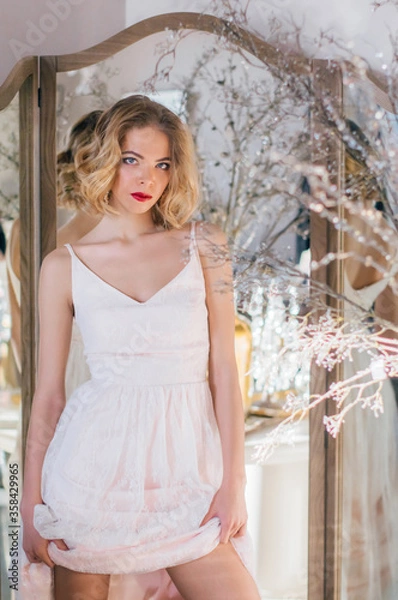 Obraz Beautiful blond girl with vintage make up and hairstyle staying near mirror