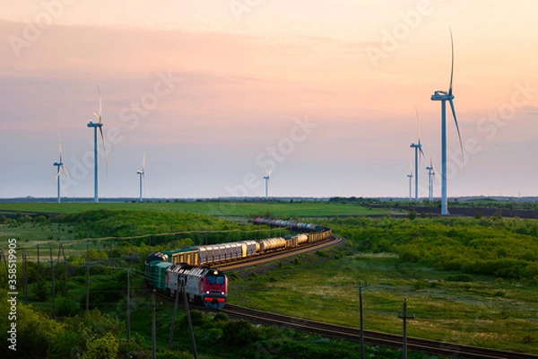 Obraz Wind farm and moving train at sunset