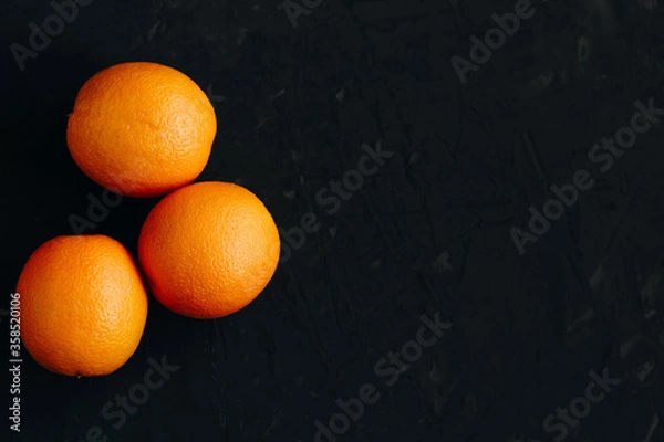 Fototapeta Oranges on black textured background.