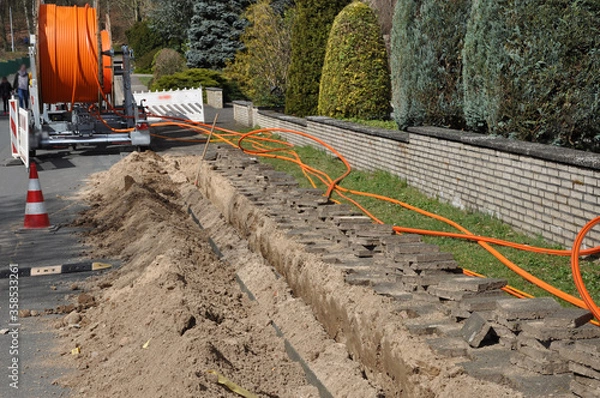 Fototapeta Netzausbau, auf der Baustelle wird Glasfaserkabel verlegt, für schnelleres Internet.