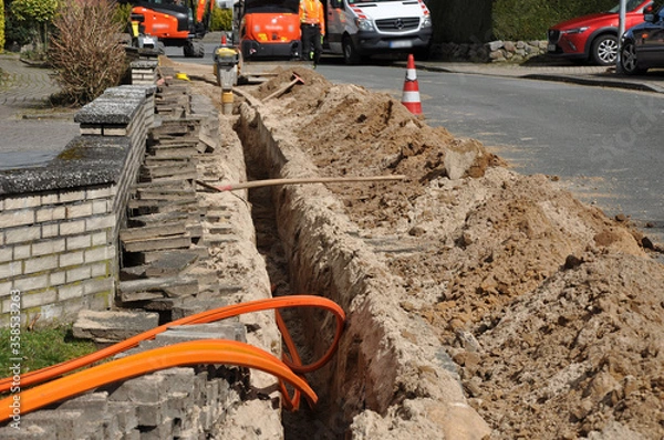 Fototapeta Netzausbau, auf der Baustelle wird Glasfaserkabel verlegt, für schnelleres Internet.