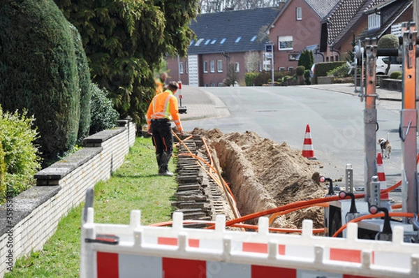 Fototapeta Netzausbau, auf der Baustelle wird Glasfaserkabel verlegt, für schnelleres Internet.