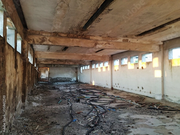 Fototapeta Opuszczona fabryka i elektrownia zbudowane głównie z ceglanych ścian o zachodzie słońca w pobliżu Dunaju, a na resztkach świeci ciemnopomarańczowe słońce