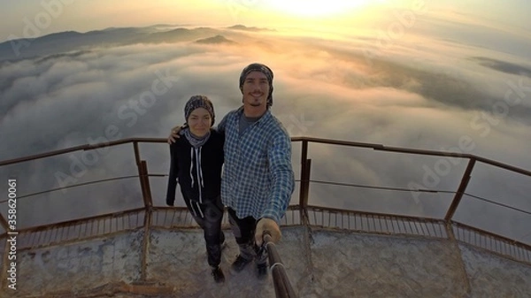 Fototapeta Camping on top of a smoke stack chimney, surrounded by fog and mist underneath the top of the building, sunrise