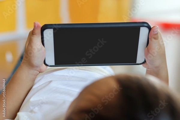 Obraz Little asian boy using a smartphone. Social and technology concept.