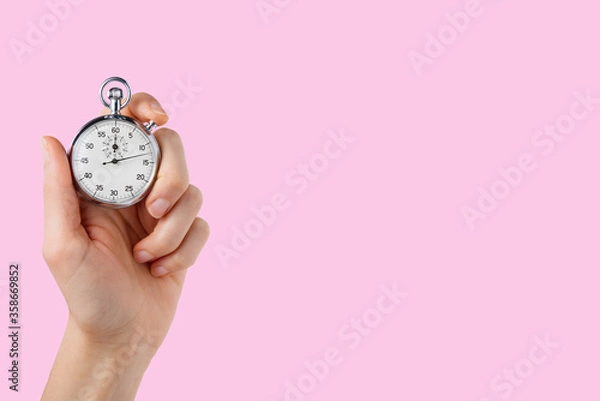 Obraz stopwatch hold in hand, button pressed, pink background