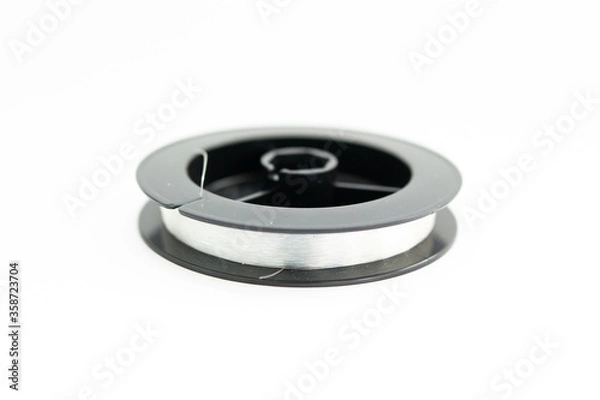 Fototapeta reel with fishing line on a white background