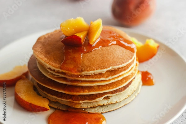 Obraz Pancakes with apricot jam and peaches. Pancakes on a plate. Tasty breakfast