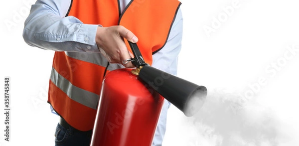 Fototapeta Worker using fire extinguisher on white background, closeup