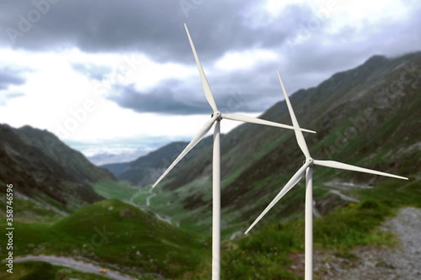 Fototapeta Alternative energy source. Wind turbines and mountains outdoors