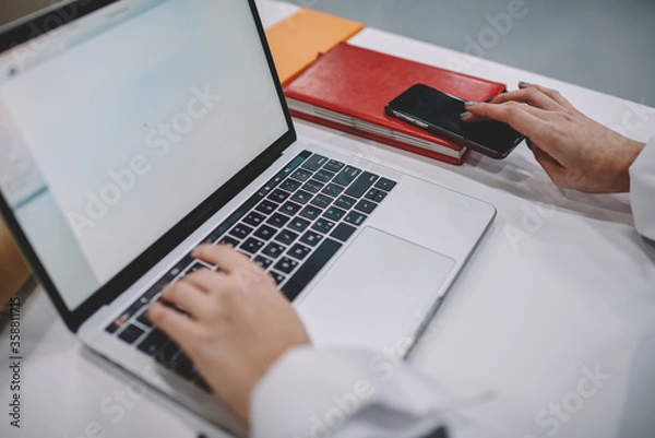 Fototapeta Selective focus on female student hands keyboarding information on laptop computer connected to wifi during preparation to exams, cropped image of woman making presentation on netbook sitting at table