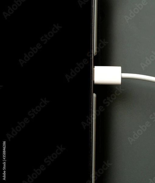 Fototapeta USB C cable connected for connecting, charging and syncing computer technology..