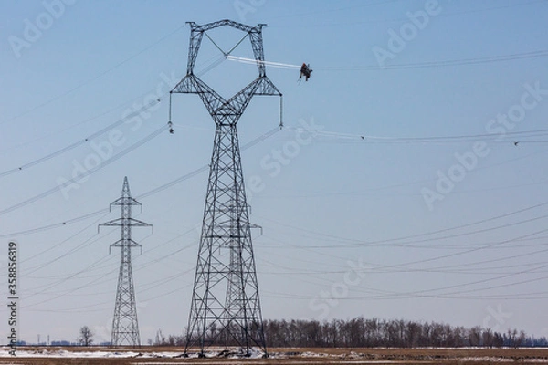 Obraz Powered cart carrying linemen on high voltage transmission line.