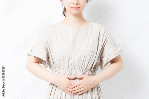 Fototapeta お腹に手を当てる若い女性