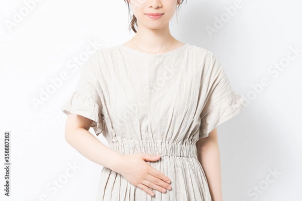 Fototapeta お腹に手を当てる若い女性