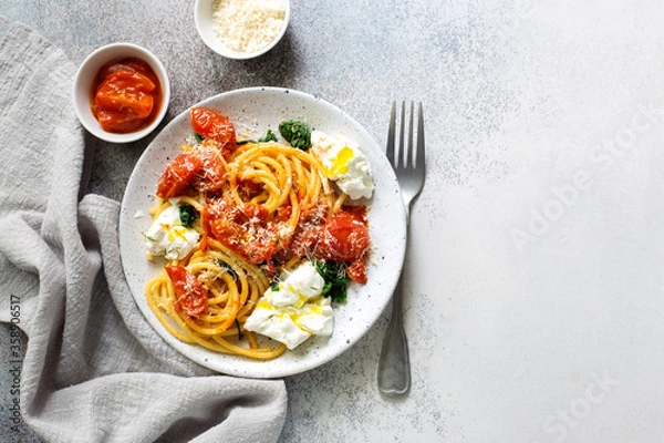 Obraz Pasta bucatini with tomato sauce, tomatoes, spinach soft cheese and parmesan cheese