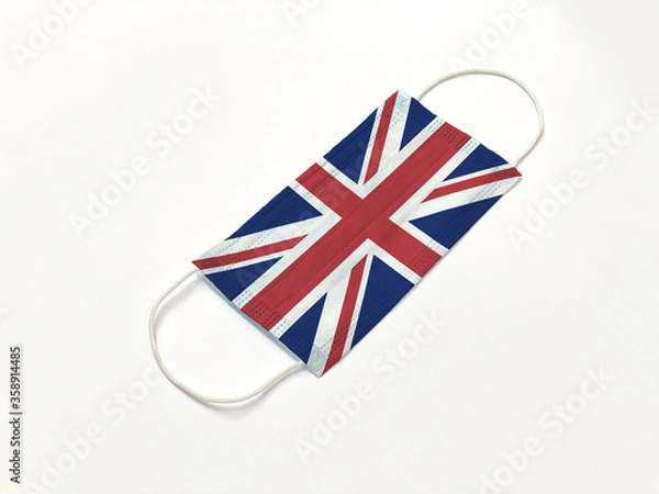 Fototapeta Concept. Disposable medical surgical face mask with United Kingdom UK country flag superimposed on it, on white background. Protection against Covid-19 virus; coronavirus outbreak.