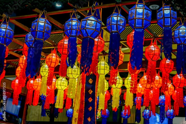 Fototapeta Closeup and look up view of decorated Thai Lanna style lanterns to hang on hotel lobby ceiling background with open lights on