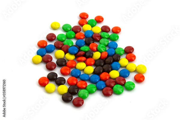 Fototapeta Colorful chocolate M&Ms in and out of focus on white background.