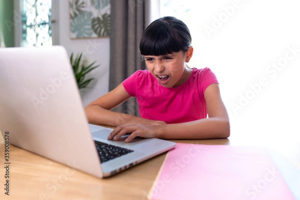 Fototapeta girl watching something disgusting her on a computer at home