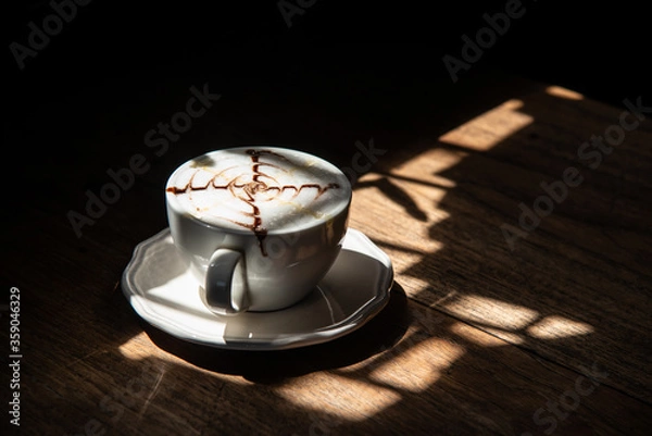 Fototapeta morning refresh window light with white cup and plate of hot milk cocoa on wood table stock photo