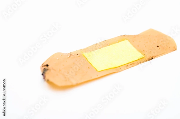 Fototapeta Used antibacterial patch on a white background in macro. Dirty patch, orange yellow top and side view