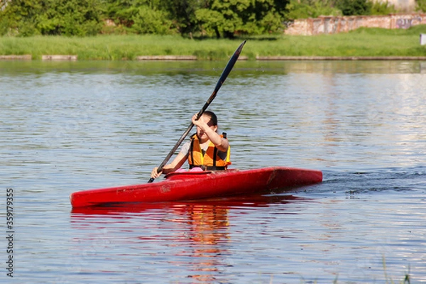 Obraz athlete on a red kayak rowing on the river