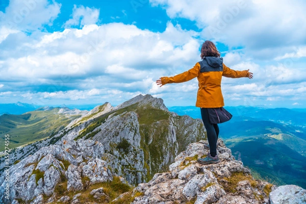 Obraz Mount Aizkorri 1523 meters, the highest in Guipúzcoa. Basque Country. Ascent through San Adrián and return through the Oltza fields. A young woman in yellow enjoying the views at the top