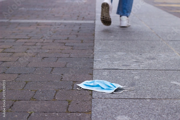 Obraz steps away from a surgical mask lying on the floor.