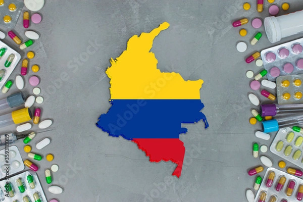 Obraz The Colombia State began research for treatment and medicine to combat the pandemic outbreak disease coronavirus. Medicine, pills, needles, syringes and Colombia  map and flag on gray background.