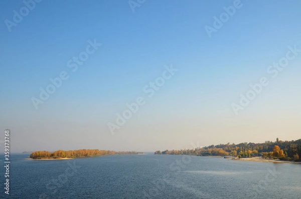 Fototapeta Bright blue sky. Autumn forest at the island and on the sandy bank of the river. View of the coast of the Dnieper River in Sosnovsky district, Cherkasy, Ukraine.