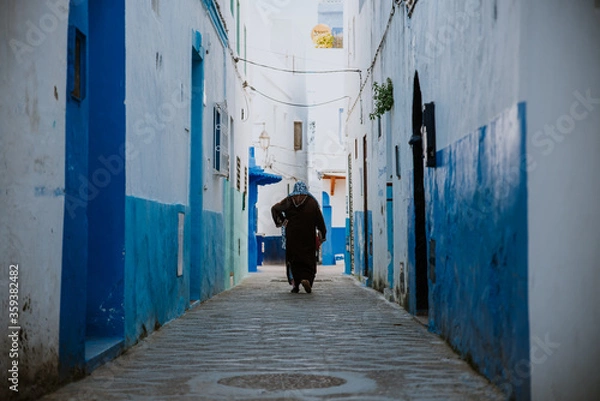Obraz Asilah, Morocco - 19 September 2019: A narrow street in with blue & white & red style.