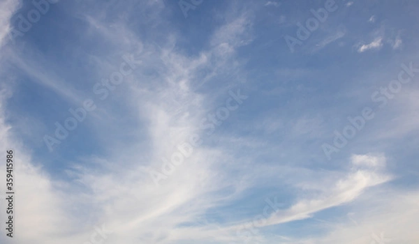 Fototapeta Whispy blue clouds just before sunset background.