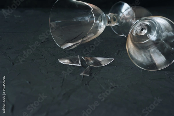 Fototapeta Broken and normal wine glass on a black background with copy space
