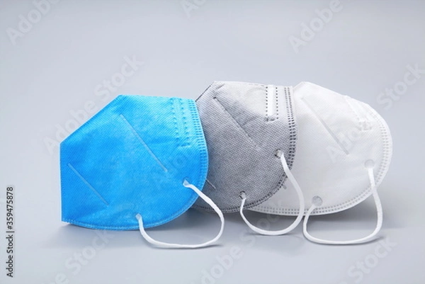 Fototapeta N95 masks in three colors are neatly placed against a gray background.COVID-19 Coronavirus outbreak.