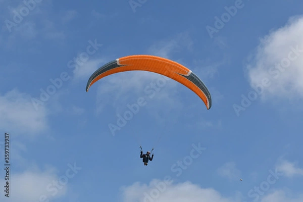 Fototapeta Paragliding at the beach of Katwijk aan Zee. Paraglider's making use of updraft of the dunes to stay in the air 