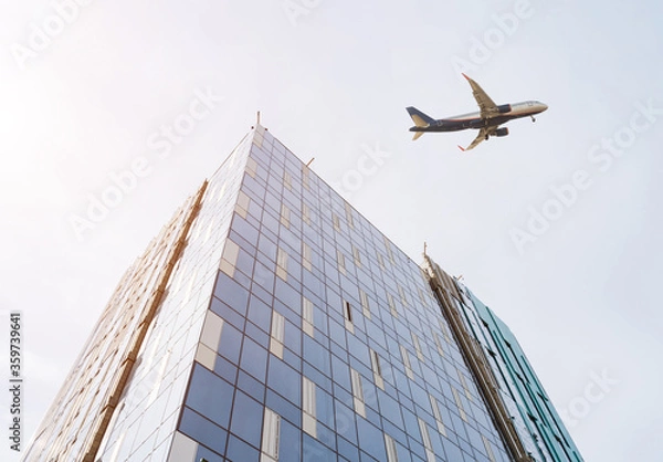 Fototapeta High-rise building under construction and plane