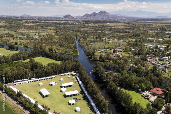 Fototapeta Aerial view of the old Cuemanco channel located in Xochimilco, Mexico City, with the Catarina mountains in the back